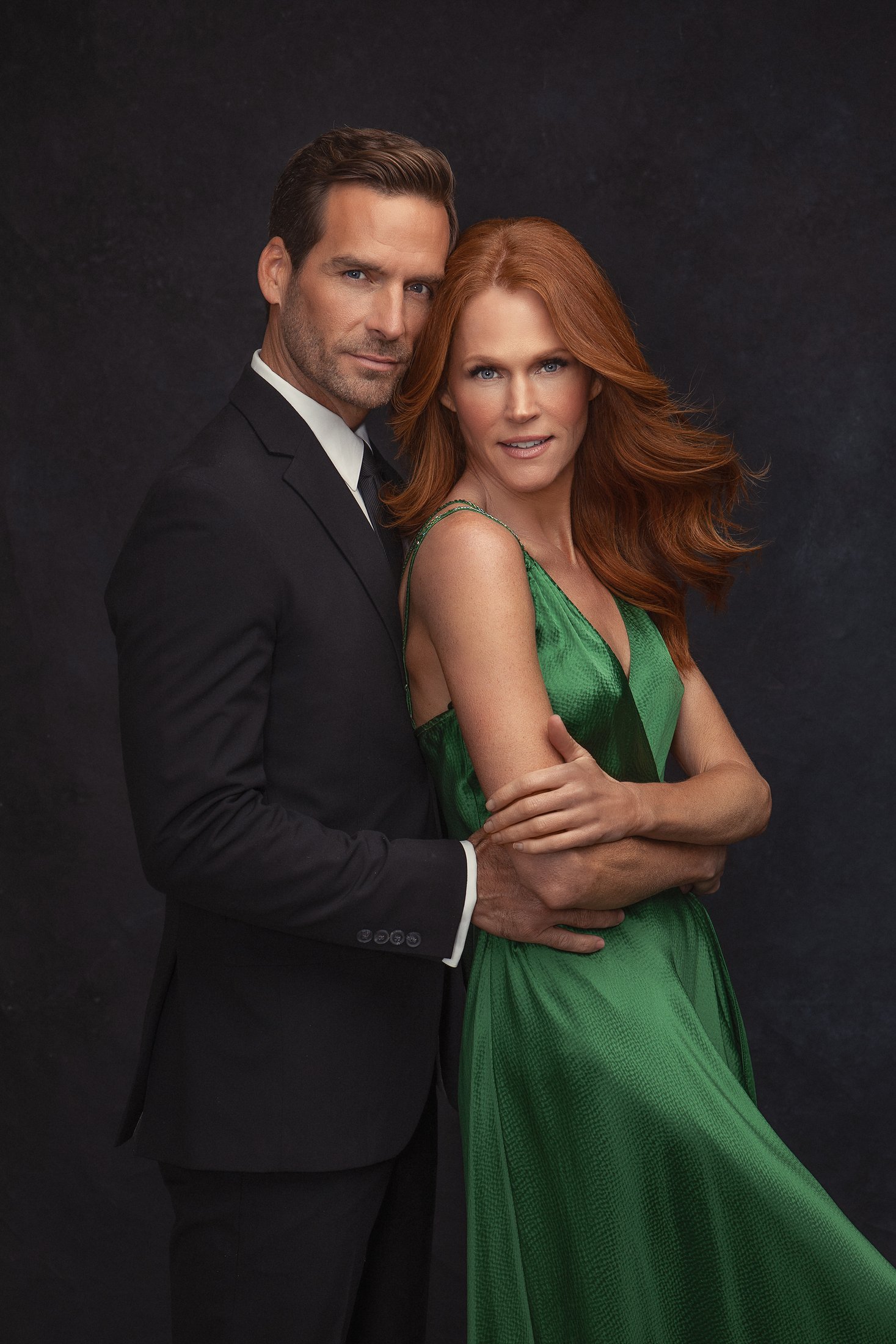 Black-tie couple portrait against a dark backdrop, Dallas studio