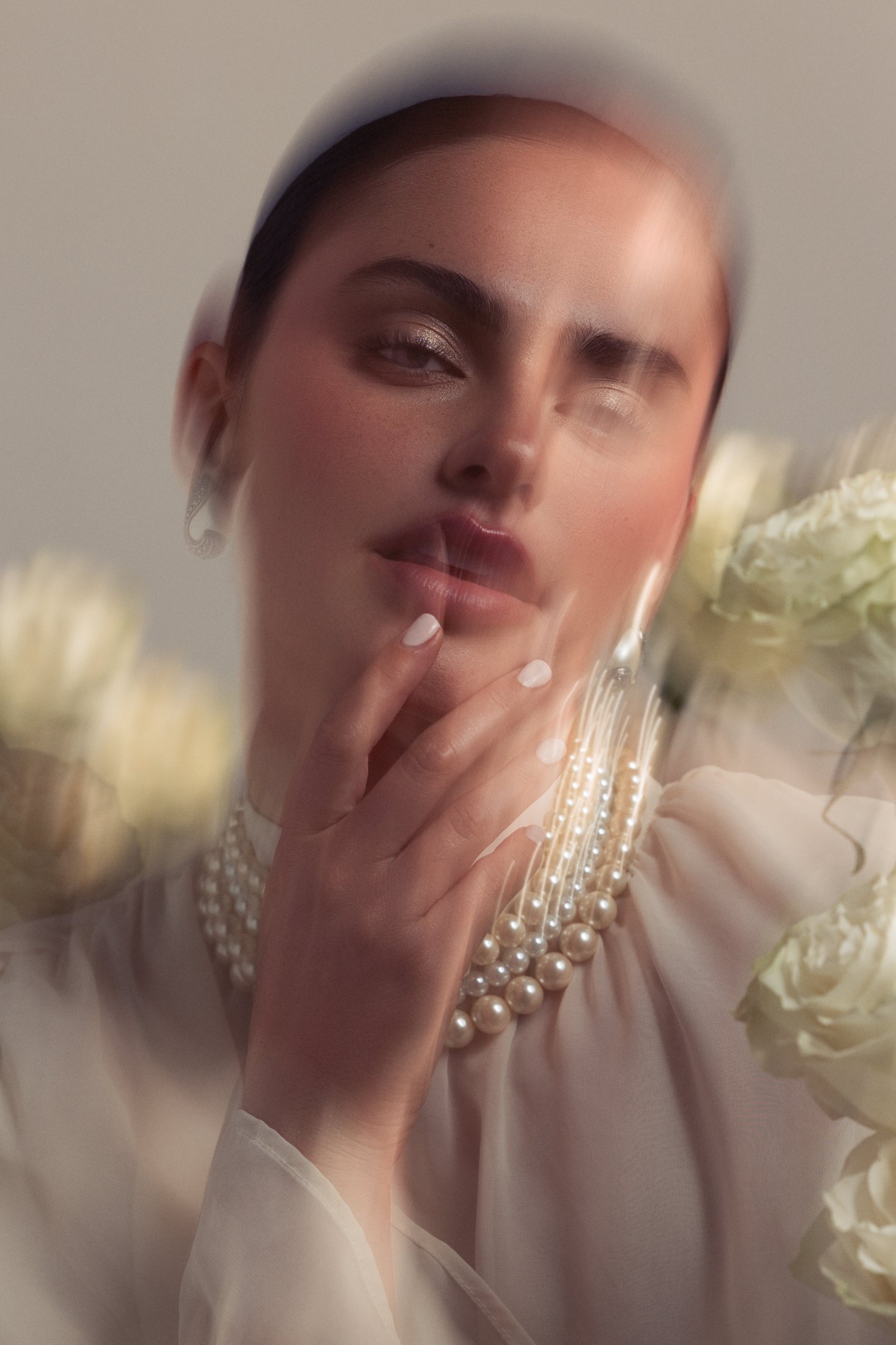 Motion-blurred portrait in pearls and white roses