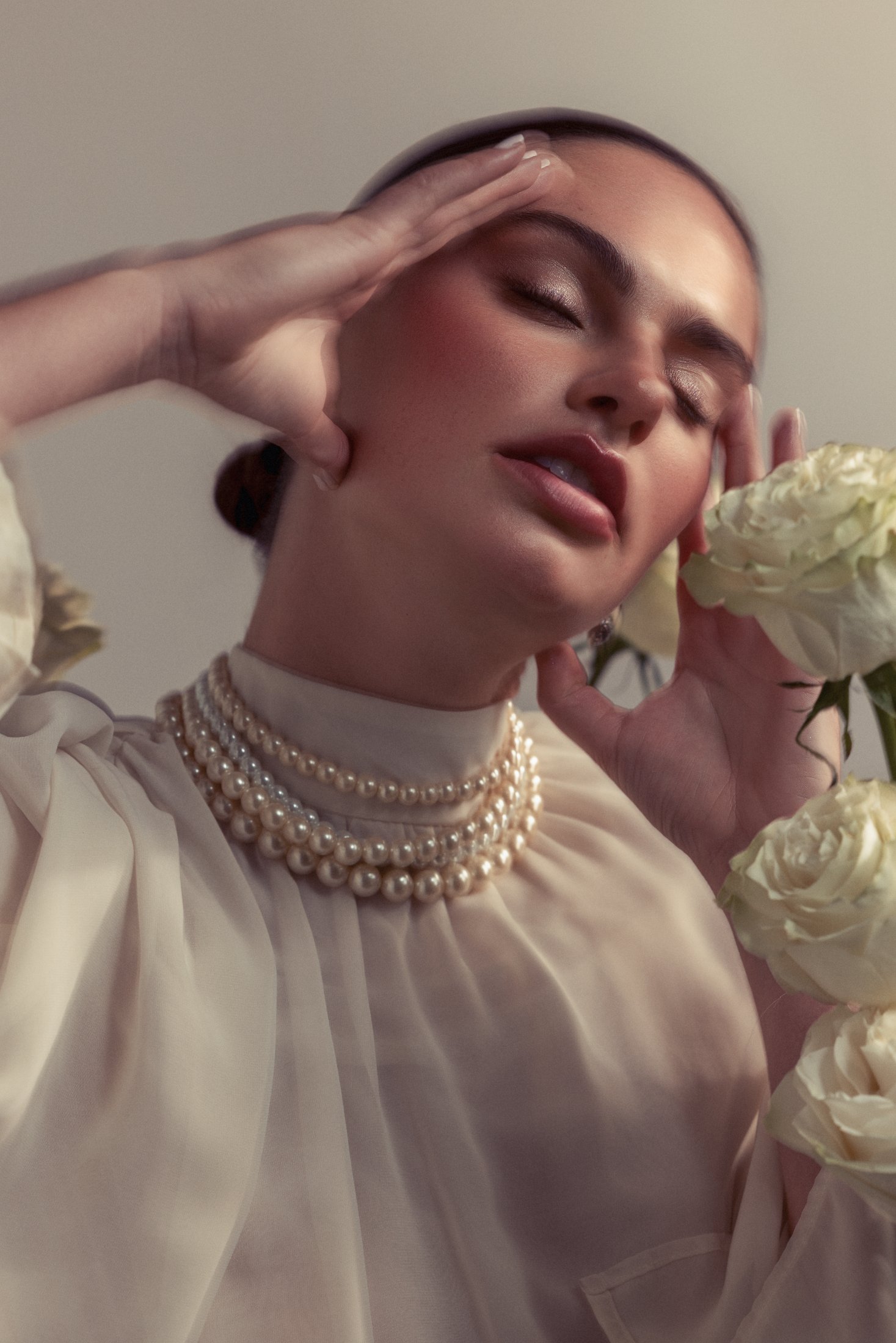Isabel Crowe in pearls and a sheer blouse with white roses