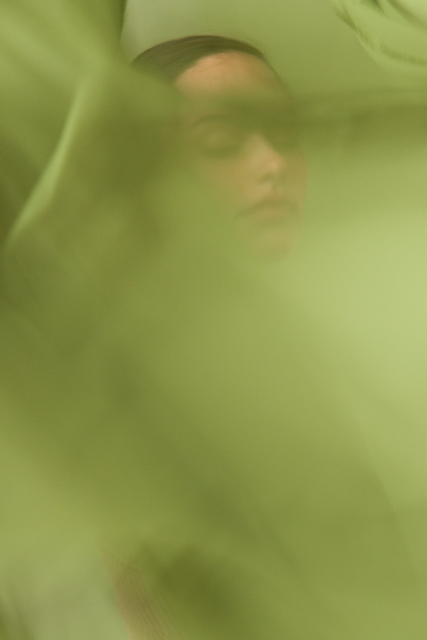 Green chiffon in motion across the frame