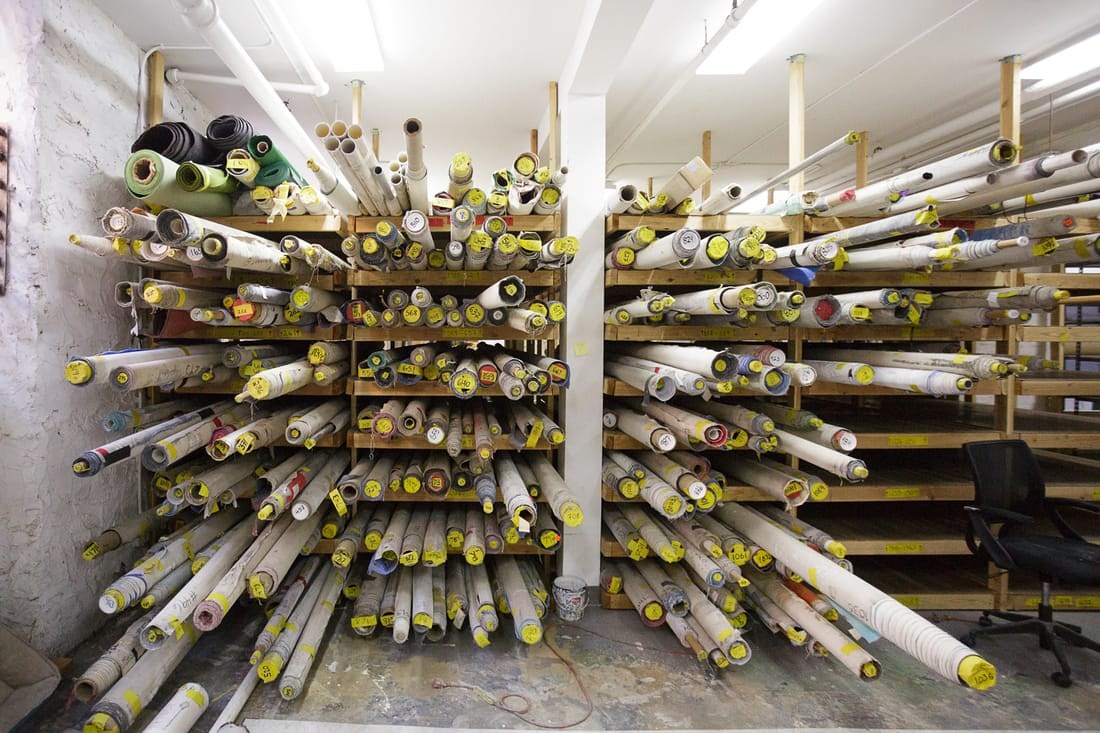 Racks of rolled hand-painted canvas backdrops at Oliphant Studio