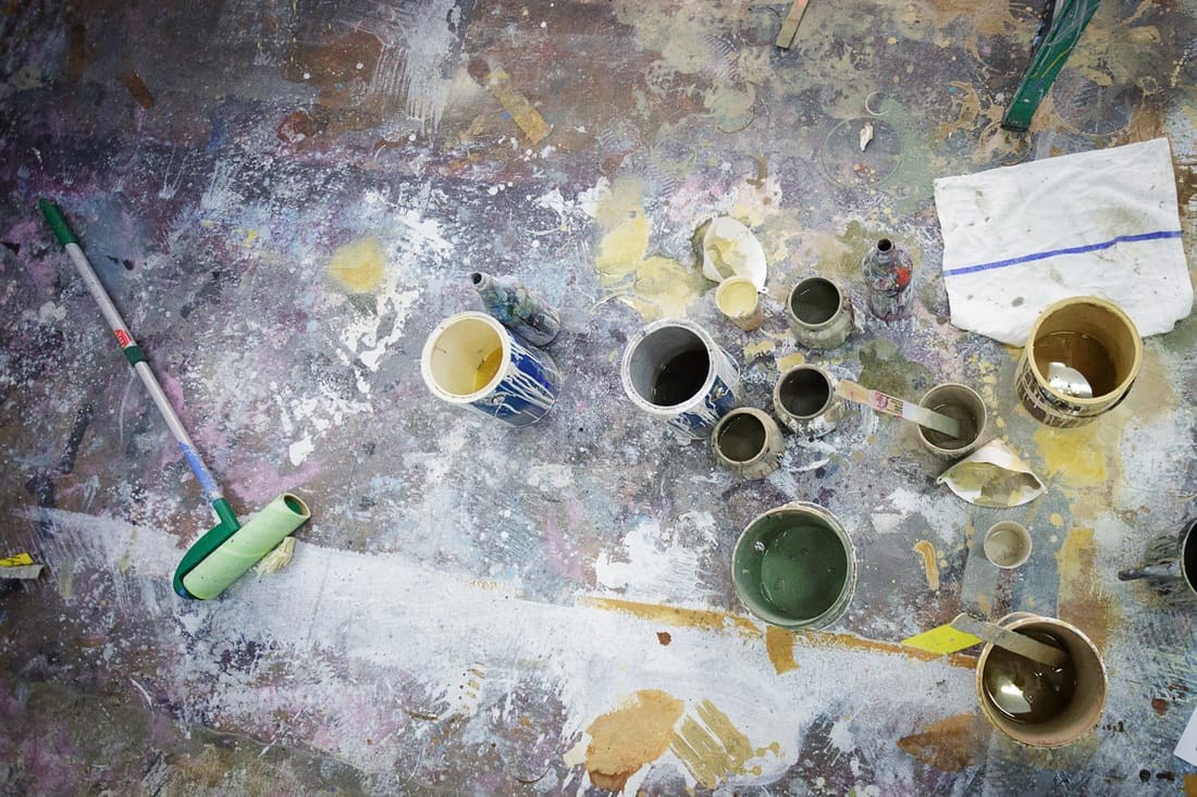 Paint pots and brushes on the floor of Oliphant Studio