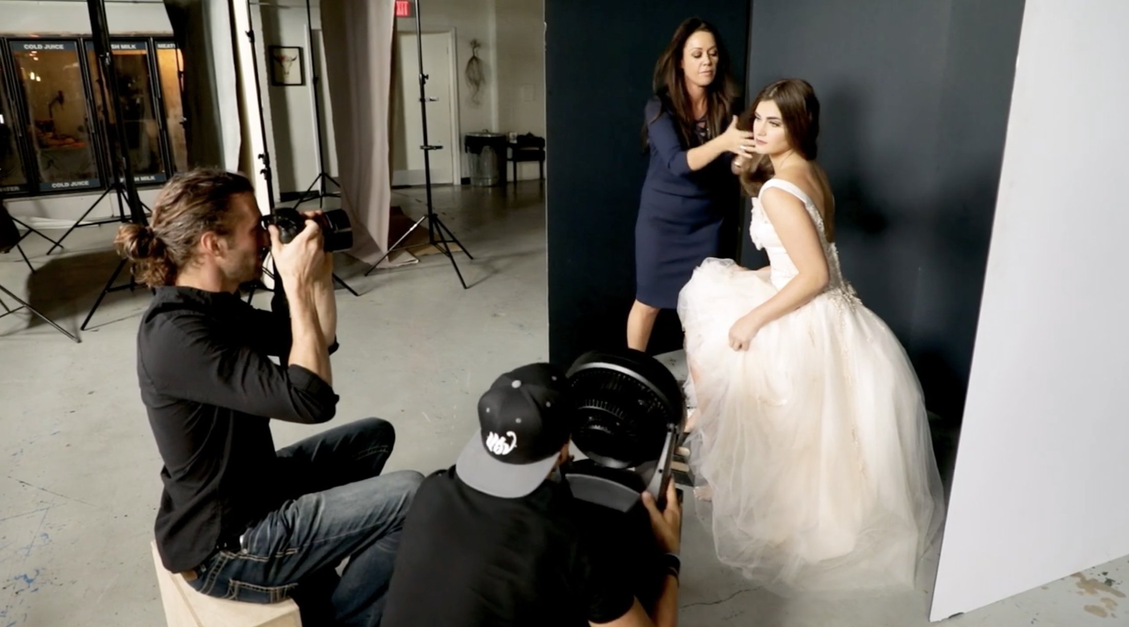 Sue Bryce adjusting a client&rsquo;s hair on set while Andrew Knowles photographs, Studio Tours filming at AJK Images, Dallas